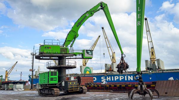 SENNEBOGEN 870 E Hafenbagger mit Mehrschalengreifer beim Schrottumschlag neben einem Frachtschiff im Hafen Hereke.