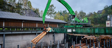 Umschlagbagger Umschlagmaschine auf Schienenportal im Sägewerk und Rundholzplatz für Holzumschlag SENNEBOGEN 835 E