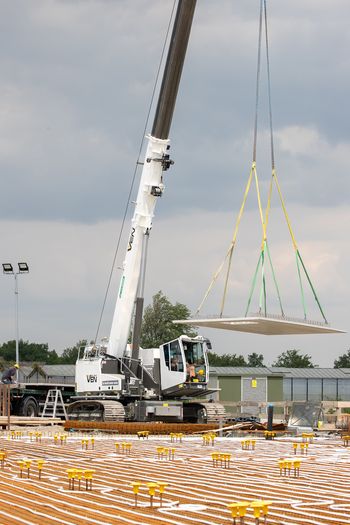 653 Electro Battery SENNEBOGEN 653 Electro Battery Kran positioniert ein Betonfertigteil beim Bau eines Elektrobusdepots in Breda.