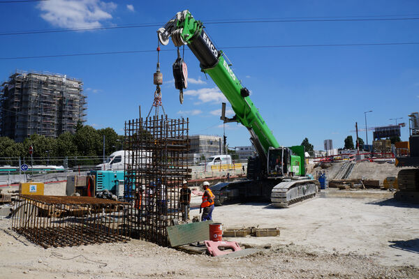 SENNEBOGEN 6113 E Crawler telecrane during lifting work on a Paris construction site