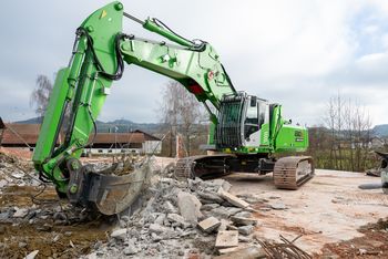 SENNEBOGEN 830 E Demolition auf Raupenfahrwerk beim Rückbau einer Betonfläche mit Abbruchschere und Schutzgitter an der Kabine.